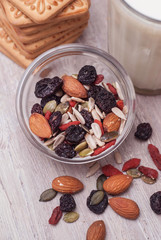 Nuts and Dried Fruits Mix on Rustic Wooden Background. Glass of Milk and Biscuits. Top view.