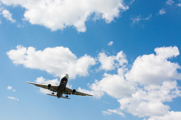 Airplane landing. Clouds and blue sky background, with copy space
