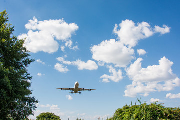 Fototapeta na wymiar Airplane landing. Clouds and blue sky background, with copy space