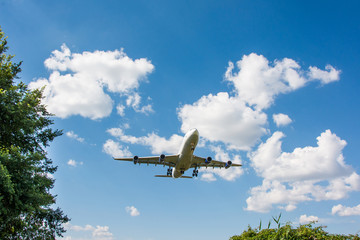 Fototapeta na wymiar Airplane landing. Clouds and blue sky background, with copy space