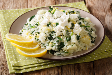 Risotto with spinach, lemon zest, onion and feta cheese close-up on a plate. horizontal
