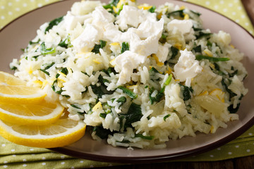 Greek cuisine: spanakorizo rice with spinach and feta cheese on a plate close-up. horizontal