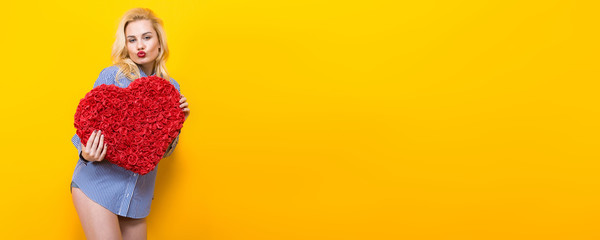 Blonde woman hold big red flower heart. Horizontal