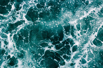 The surface of the sea with waves,  splash,  foam and bubbles, green abstract background