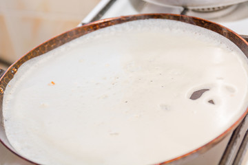 Pancakes are fried in a frying pan. Fried pancakes. Cooking pancakes. Russian folk dish. Maslenitsa.