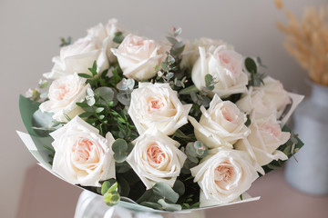 beautiful luxury bouquet of white rose on wooden table. the work of the florist at a flower shop. David Austin