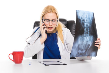 Woman doctor in white coat carefully studies X-ray