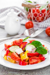 Tomato salad with fresh bell pepper, red onion and feta cheese. Healthy eating