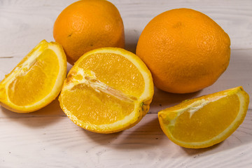 Fototapeta na wymiar Fresh oranges on white wooden table