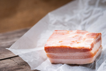Raw bacon over wooden background