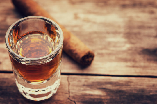 Whiskey or bourbon in a shot glass and cigar 