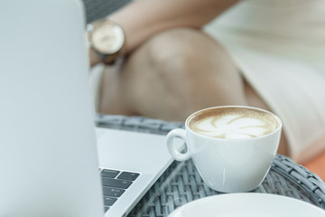 A coffee cup and white plate on the mirror table.