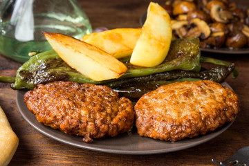 homemade grilled burgers with chips and peppers on rustic wood