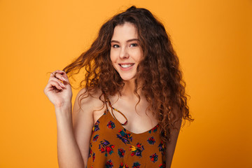Obraz premium Cute young lady standing isolated over yellow background