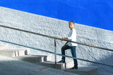 Fototapeta na wymiar Young caucasian boy walking up stairs outdoors.