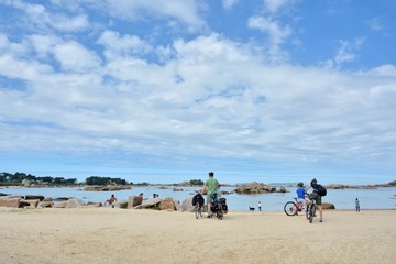 Une famille de randonneurs en vélo sur la côte de granit rose en Bretagne