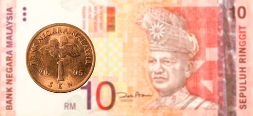 1 malaysian sen coin against 10 malaysian ringgit bank note obverse
