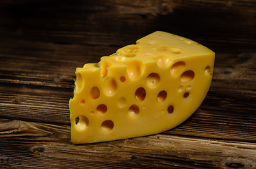 Piece of cheese on wooden table