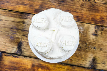 Homemade birthday's white cake for 7 year-old boy Round cake in the shape of brick. Top view