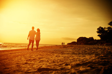 Summer golden sunset and two lovers on beach 