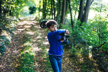 child with metal detector in the woods in spring