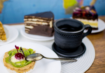 Various cakes and a clay cup with coffee.