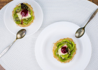 Two cakes - baskets on white plates. One plate is bigger than the other.