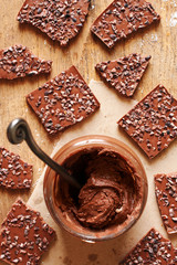 Top view of homemade nutella with chocolate pieces on the background. 