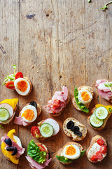 Top view of variety of healthy sandwiches on wooden table with space for text.