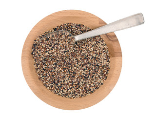 Quinoa seeds in wooden bowl with metal desert spoon, isolated.