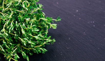 Bunch of fresh thyme on a black background. Top view image. Copyspace for your text