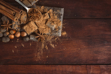 Chocolate, Spices, Spoon with Cocoa on the Wooden Background. Copy space. Flat lay, top view