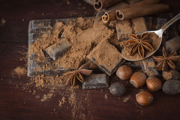 Chocolate, Spices, Spoon with Cocoa, Hazelnut on the Wooden Background. Copy space