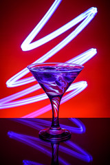 Martini glass on a red background with blue lights
