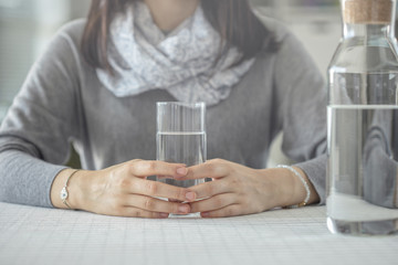 Young woman holding glass of water