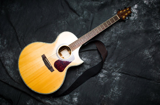 Acoustic guitar in a case on dark background