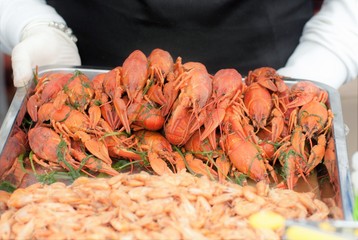 Presentation of crayfish and shrimp welded and laid out on a tray.