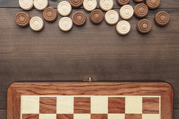 wooden draughts game on brown table background - obrazy, fototapety, plakaty