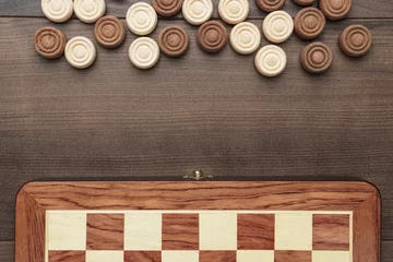 Foto op Canvas wooden draughts game on brown table background © Ruslan Grumble