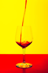    51/5000 red wine poured into a glass on a yellow background