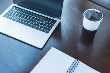 high angle view of laptop and cup of coffee on table in office