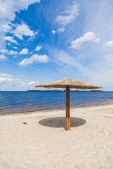 Sunshade on sandy beach on summer day