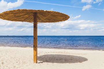 Sunshade on sandy beach on summer day