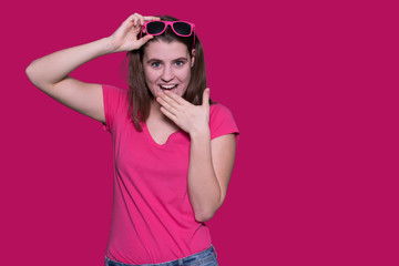 Beautiful teenager girl wearing pink sunglasses laughing on isolated background