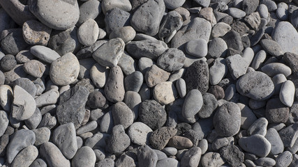 Grey smooth pebble beach background with copy space, conceptual texture from nature