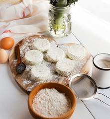 raw cheese cakes with poppy seeds on a wooden surface. with ingredients