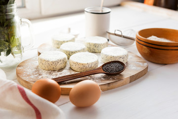 raw cheese cakes with poppy seeds on a wooden surface. with ingredients