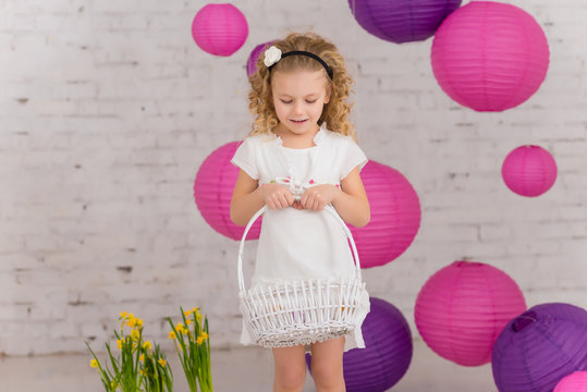 Cute little girl holds easter eggs basket