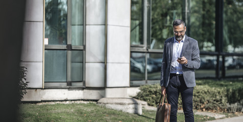 Businessman Typing on Cell Phone