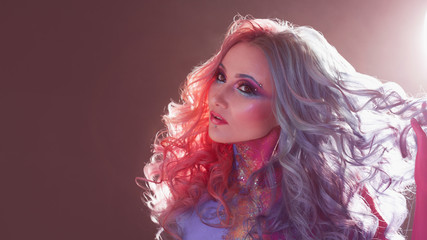 Beautiful woman with bright hair. Bright hair color, hairstyle with curls.